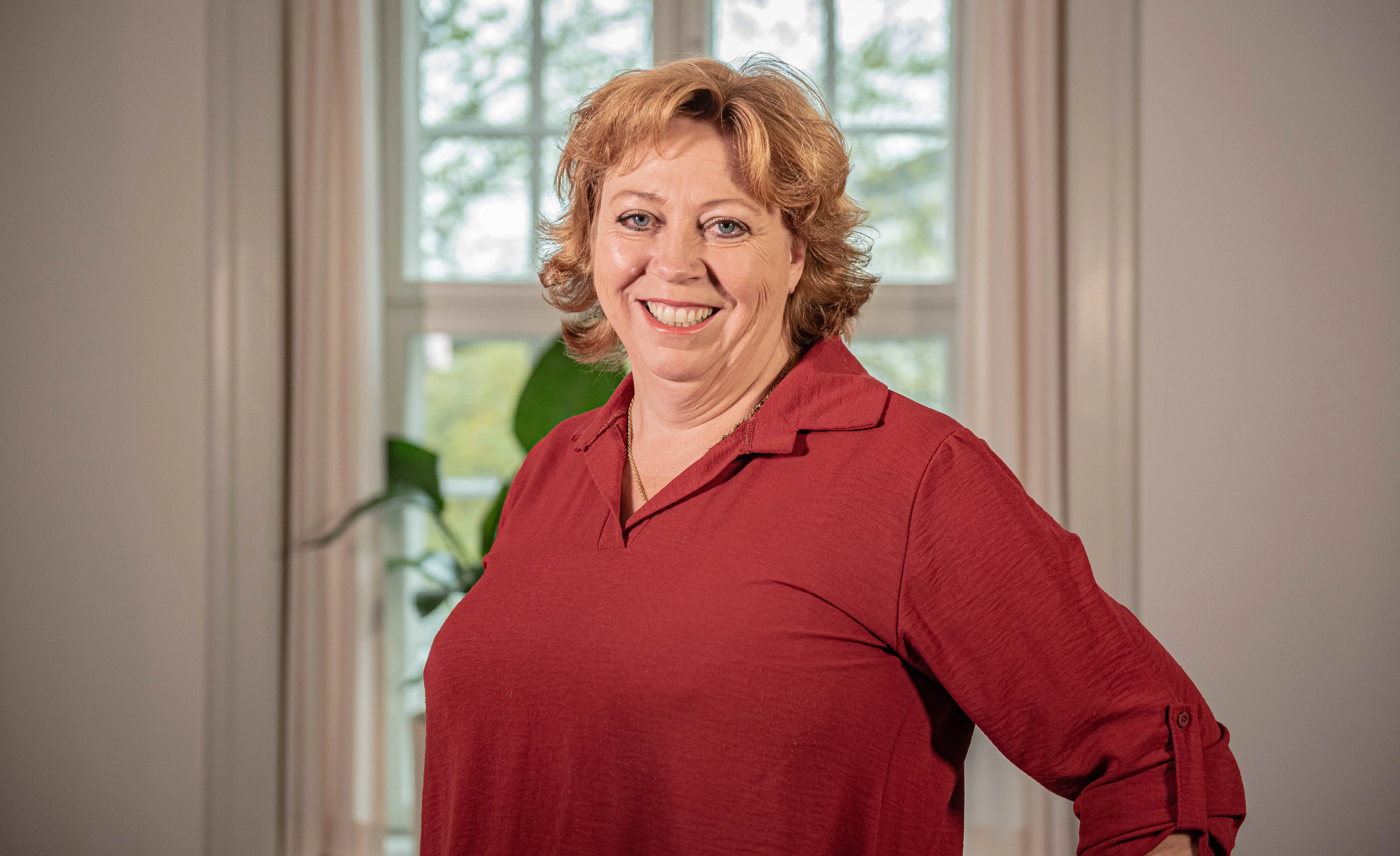 Foredragasholder Karen-Marie Lillelund, rød bluse, foran vindue